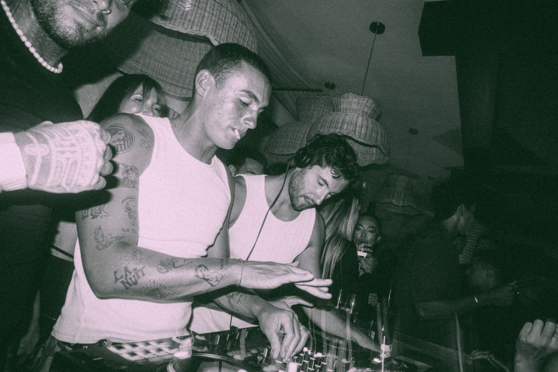 Two DJs at the decks, black and white