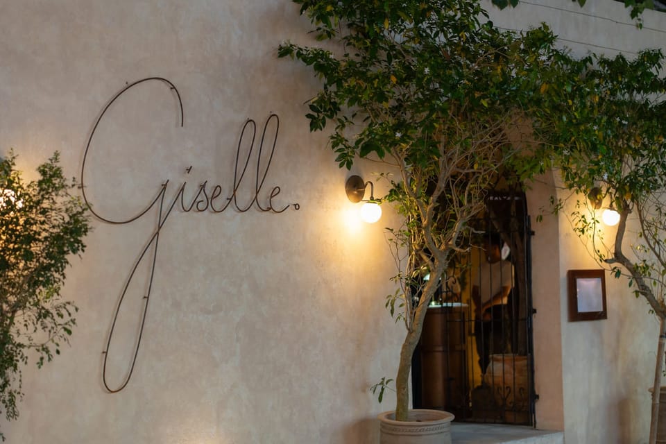 The facade at night with the Giselle sign